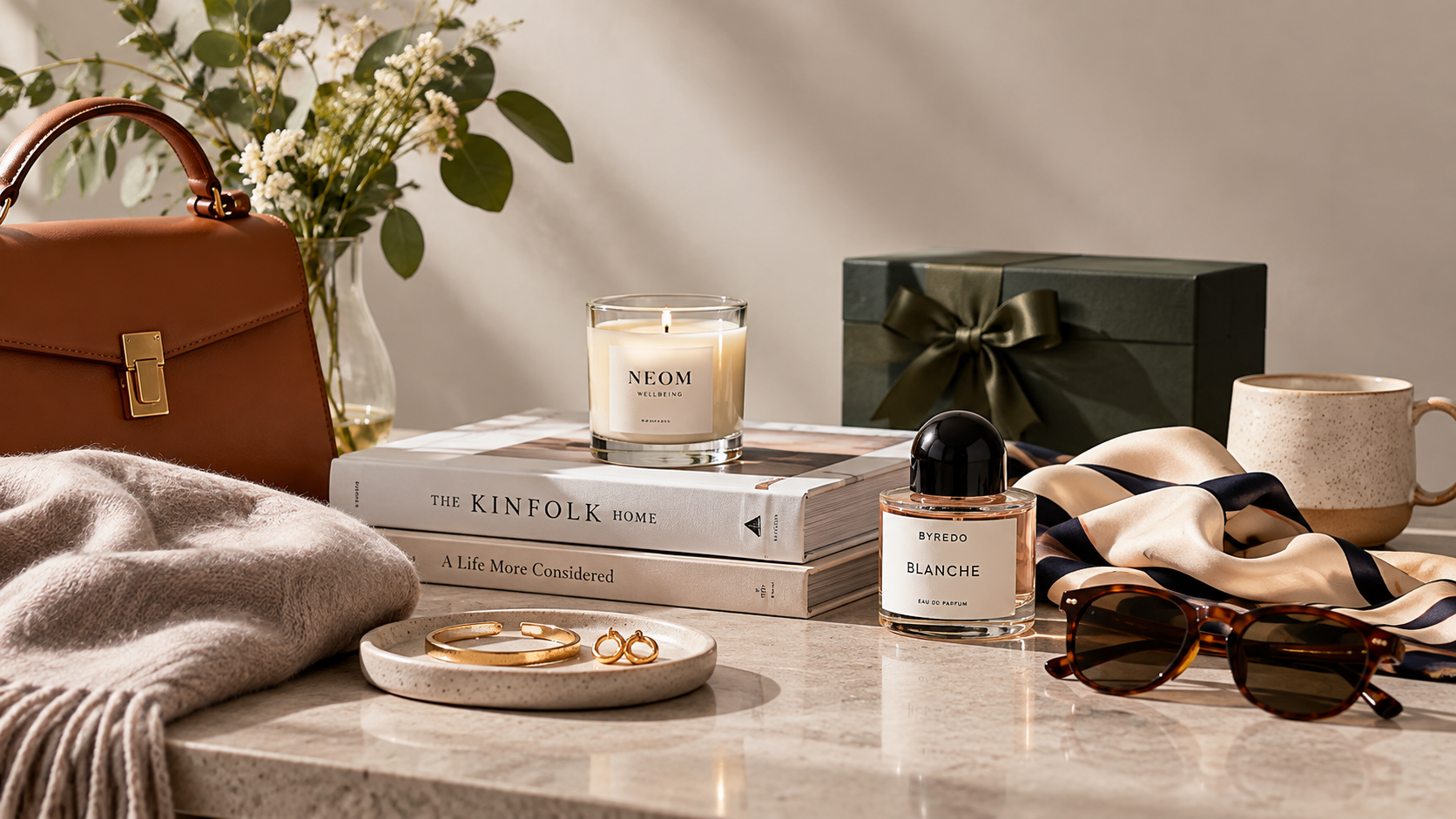 A collection of gift inspiration, including a handbag, candle, fragrance, jewellery, books and accessories